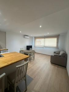 a kitchen and living room with a table and a couch at Set Blau Apartamentos in El Prat de Llobregat