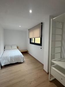 a bedroom with a bed and a window and a closet at Set Blau Apartamentos in El Prat de Llobregat +11 photos