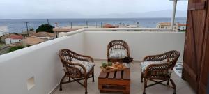 two chairs and a table on a balcony with the ocean at Local Paradise Xilokastro in Xylokastro