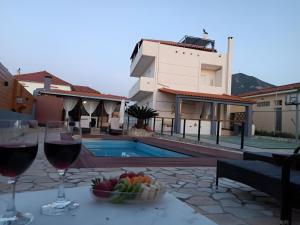 a table with two glasses of wine and a bowl of fruit at Local Paradise Xilokastro in Xylokastro