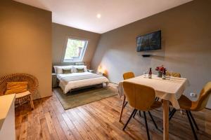 a bedroom with a bed and a table and chairs at Ryckevelde in Damme