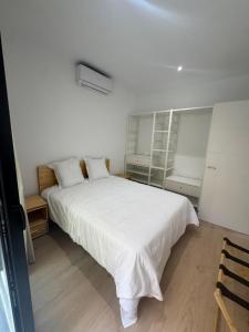a bedroom with a large white bed with white sheets at Set Blau Apartamentos in El Prat de Llobregat