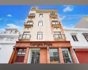 a tall white building with a sign on it at Ganges Pride Hotel in Haridwār