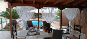 a dining room with a table and a view of a pool at Local Paradise Xilokastro in Xylokastro