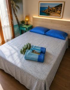 a bed with blue pillows and a tray on it at St Jordi Hagdigadar Tossa in Tossa de Mar