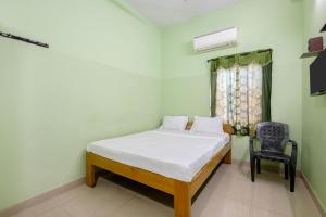 a small bedroom with a bed and a chair at Hotel Sridevi Grand in Vākalapūdi
