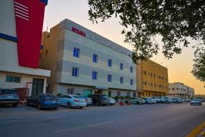 a building with cars parked in a parking lot at Dar NEYAARA SERVICED APARTMENTS - Economic in Riyadh
