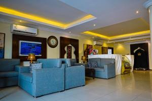 a living room with blue couches and a clock at Dar NEYAARA SERVICED APARTMENTS - Economic in Riyadh