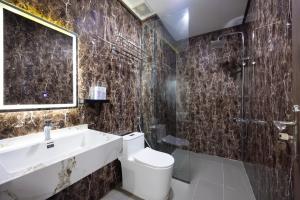 a bathroom with a toilet and a sink and a shower at TH Luxury Hotel 2 in Phú Quốc
