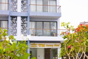 a white building with a sign that reads thy agency hotel at TH Luxury Hotel 2 in Phú Quốc