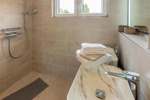 a bathroom with a shower and a tub with towels at MeerBlau in Dornumersiel