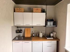 a kitchen with white cabinets and a counter top at Kauguri apartment residence in Jūrmala