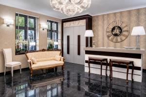 a living room with a couch and a chandelier at Monaco Ville Wellness in Międzyzdroje