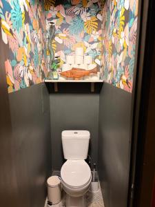 a bathroom with a toilet with a colorful wallpaper at Kauguri apartment residence in Jūrmala +6 photos