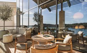 a patio with a couch and tables and chairs at Monte Mulini Adults Exclusive Hotel by Maistra Collection in Rovinj