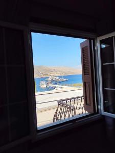 a window with a view of a harbor with boats in the water at Kalymnos Sea View Villa in Kalymnos