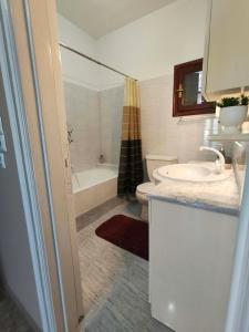 a bathroom with a sink and a toilet and a tub at Kalymnos Sea View Villa in Kalymnos