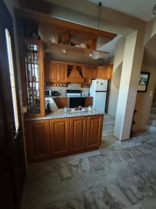 a kitchen with wooden cabinets and a white refrigerator at Kalymnos Sea View Villa in Kalymnos +30 photos