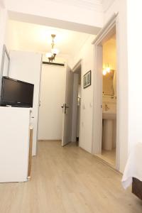 a white room with a television and a bathroom at Bozcaada Su otel in Bozcaada