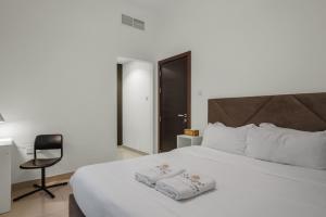 a bedroom with a white bed and a chair at 3BR villa BBQ Pool and Maidroom near diving center Dana Island in Sharm