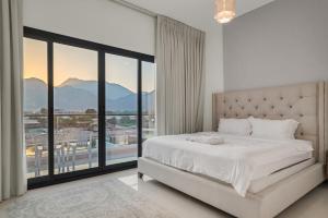 a white bedroom with a bed and a large window at 3BR villa BBQ Pool and Maidroom near diving center Dana Island in Sharm