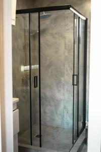 a shower with a glass door in a bathroom at Kolsay Lake Cabins in Kurmenty
