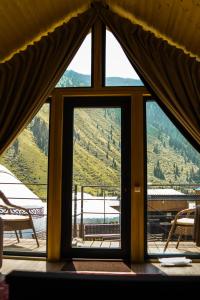a window in a room with a view of a mountain at Kolsay Lake Cabins in Kurmenty