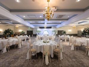 a banquet hall with white tables and chairs and a chandelier at Mercure Barnsley Tankersley Manor Hotel in Barnsley +232 photos