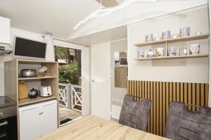a kitchen and dining room with a table and chairs at Tiny Homes Nr 822 in Göhren +23 photos