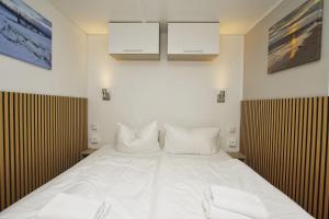 a bedroom with a large white bed with two white pillows at Tiny Homes Nr 822 in Göhren