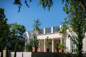 a white house with potted plants on it at Scharioth Birtok in Nagyréde