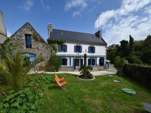 a white house with a red chair in the yard at Brittany Escape with Garden in Kersaudy