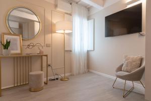a living room with a mirror and a chair at Residenza Isotta in Rimini