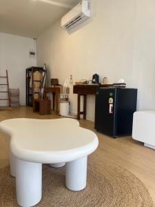 a white coffee table in a room with a desk at Nomad Beach House, Koh Lanta in Ko Lanta