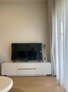 a living room with a large television on a white cabinet at Nomad Beach House, Koh Lanta in Ko Lanta