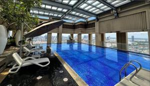 a swimming pool with chairs and an umbrella in a building at Tian Yue Hotel in Phnom Penh