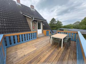 a deck with a table and chairs on a house at Schwalbennest Flensburger Förde in Westerholz