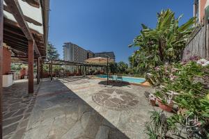 an outdoor patio with a swimming pool and plants at SweetWater Villa - Pool - Solarium - Smart TV in Savona