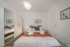 a white bedroom with a large bed and a mirror at SweetWater Villa - Pool - Solarium - Smart TV in Savona +26 photos