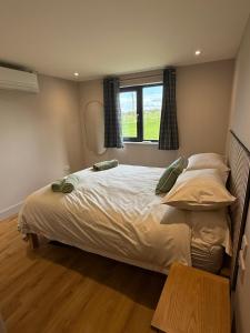 a bedroom with a large bed and a window at Caerketton View Lodges in Loanhead