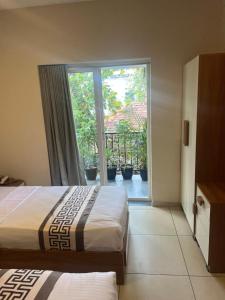 a hotel room with two beds and a sliding glass door at 88 villaggio Edappally in Edappally
