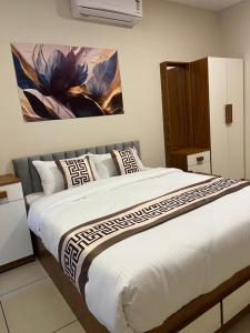 a bedroom with a large bed with a painting on the wall at 88 villaggio Edappally in Edappally