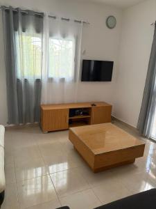 a living room with a coffee table and a flat screen tv at Villa Clémence in Mbour