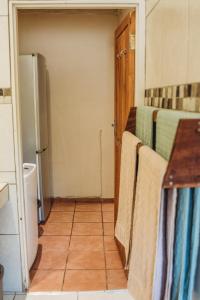 a kitchen with a refrigerator and towels on the racks at Charming Self Catering Apartment in Phalaborwa