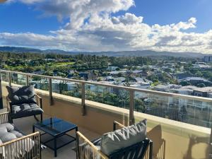 a balcony with chairs and a view of a city at Lumi Residence Robina in Gold Coast