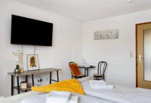 a bedroom with two beds and a flat screen tv on the wall at Seelina in Perach