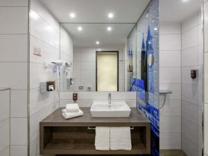 a bathroom with a sink and a mirror at ibis Styles Magdeburg in Magdeburg +73 photos