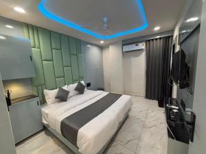 a bedroom with a large bed with a blue ceiling at Hotel Planet Lake in Ahmedabad +20 photos