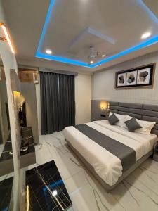 a bedroom with a large bed and a blue light at Hotel Planet Lake in Ahmedabad