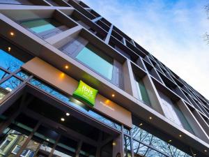 a building with a green sign on the side of it at ibis Styles Pforzheim in Pforzheim